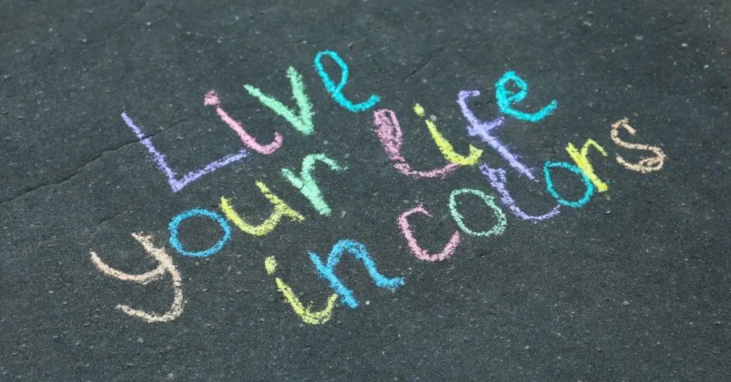 i am affirmations for kids +  Written in chalk on the ground: "Live your life in colors"