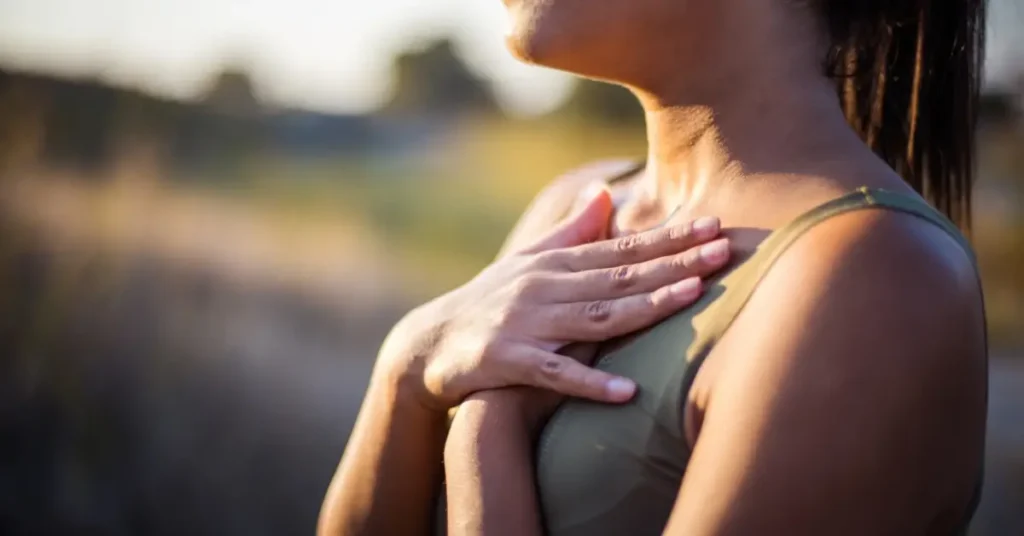 somatic breathwork + A woman places her hands on her collarbone and focuses on her breath