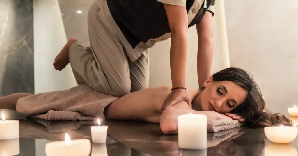 somatic breathwork + A woman lies on her stomach receiving a massage from a therapist