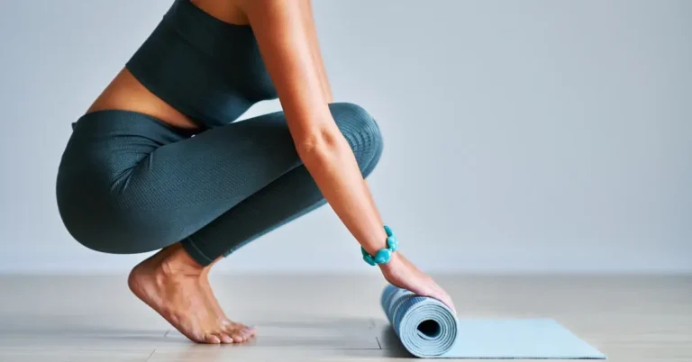 pilates workout at home + A woman is rolling up her mat to do Pilates
